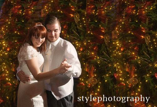 Bride and groom having their first dance at their Christmas wedding with fairy lights in the background