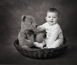 Baby in a basket with teddy